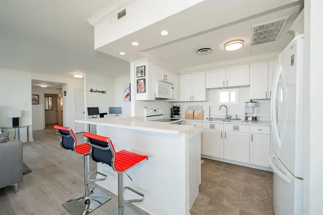 a kitchen with kitchen island stainless steel appliances a sink and cabinets