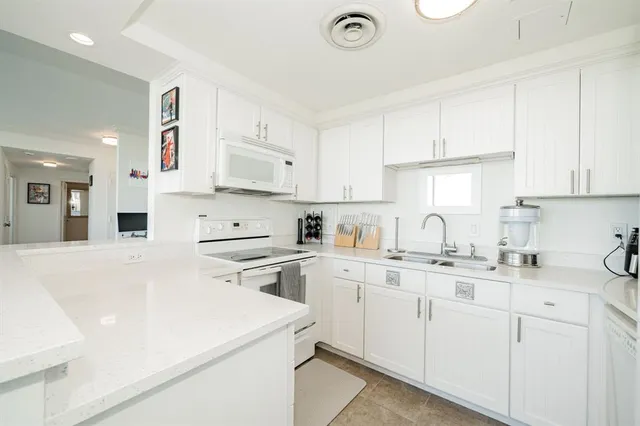 a kitchen with cabinets appliances a sink and a counter top space