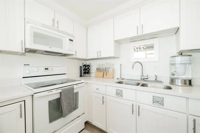 a kitchen with cabinets stainless steel appliances and sink