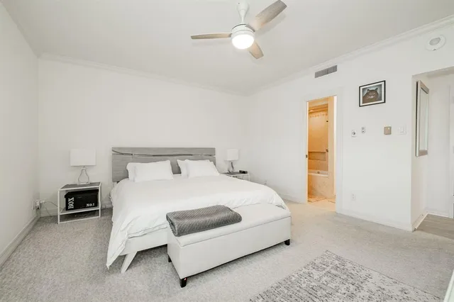 a bedroom with a bed lamp and a table