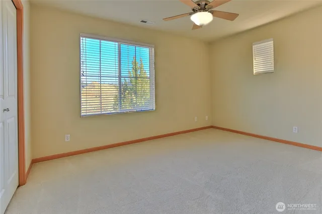 an empty room with a window and a ceiling fan