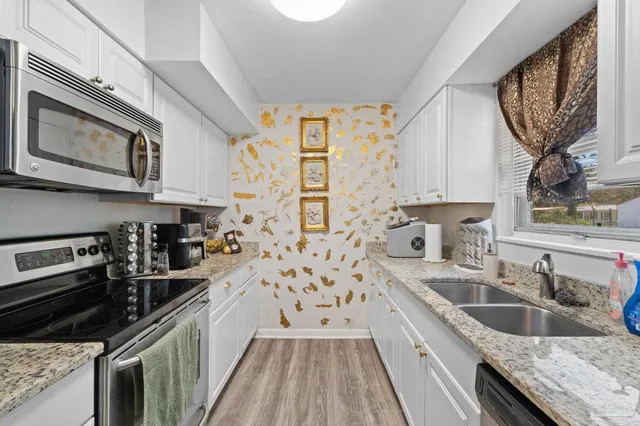 a kitchen with a sink stove top oven and cabinets