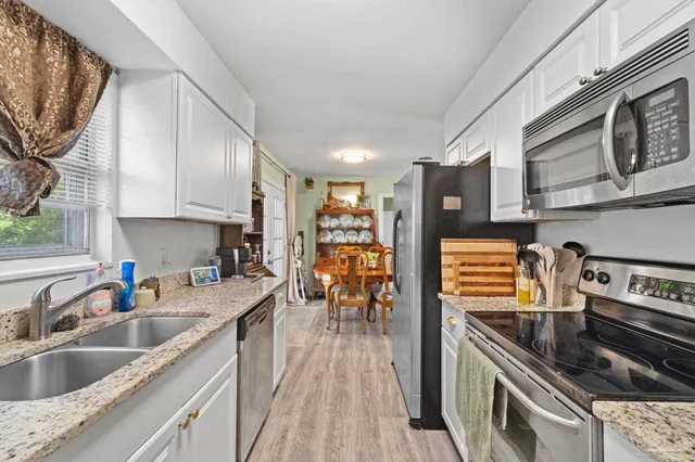 a kitchen with stainless steel appliances granite countertop a stove and a sink