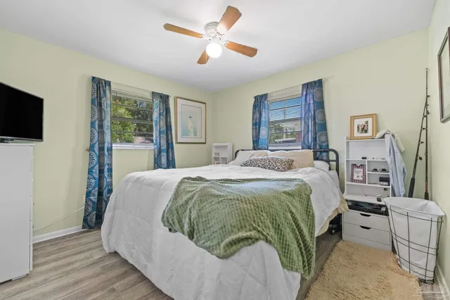 a spacious bedroom with a bed and a flat screen tv