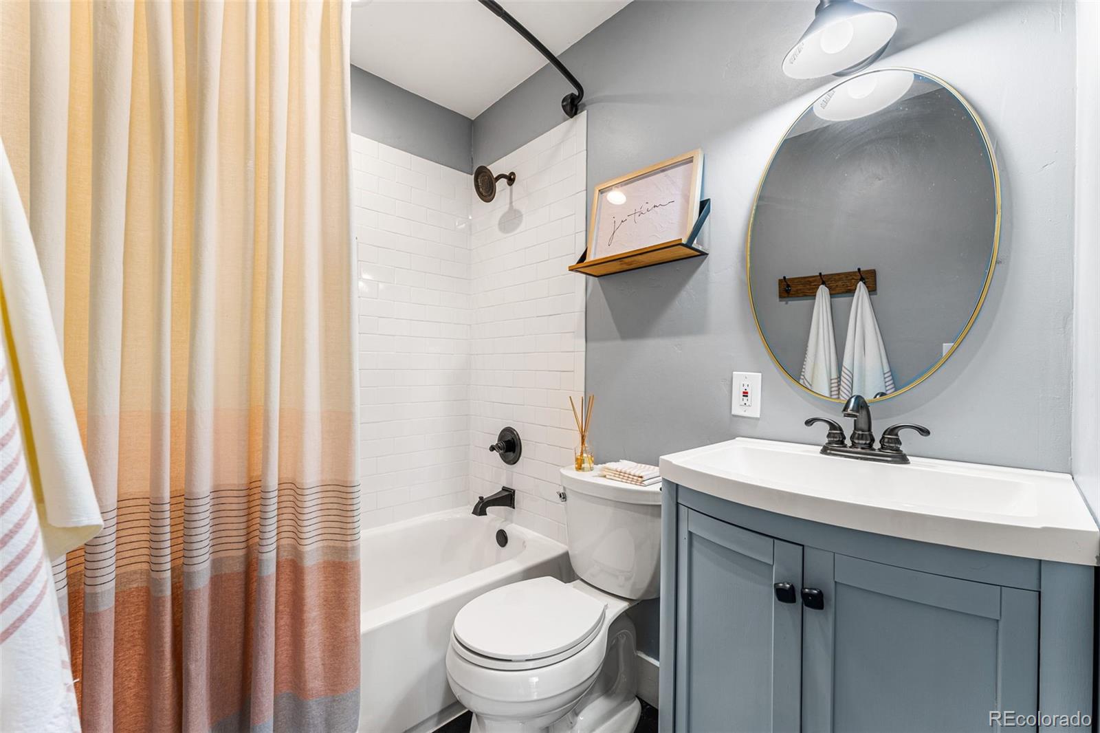30242 Pine Crest Drive Evergreen, CO 80439 - Photo 17 of 28 a bathroom with a sink a toilet and shower curtain