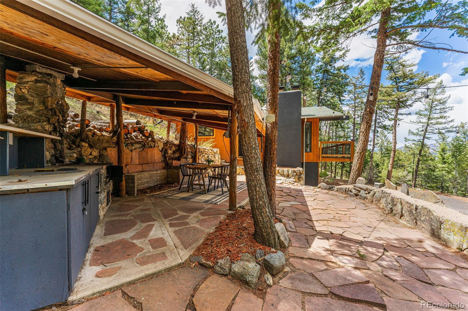 30242 Pine Crest Drive Evergreen, CO 80439 - Photo 25 of 28 a view of a patio with a table chairs and a backyard