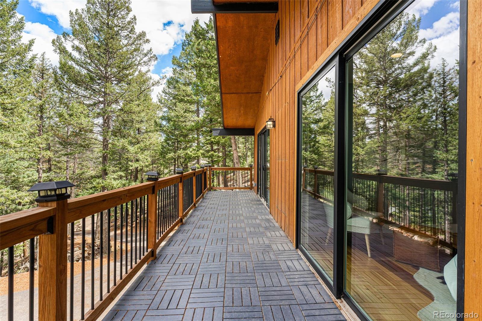 30242 Pine Crest Drive Evergreen, CO 80439 - Photo 9 of 28 a view of balcony with wooden floor and fence