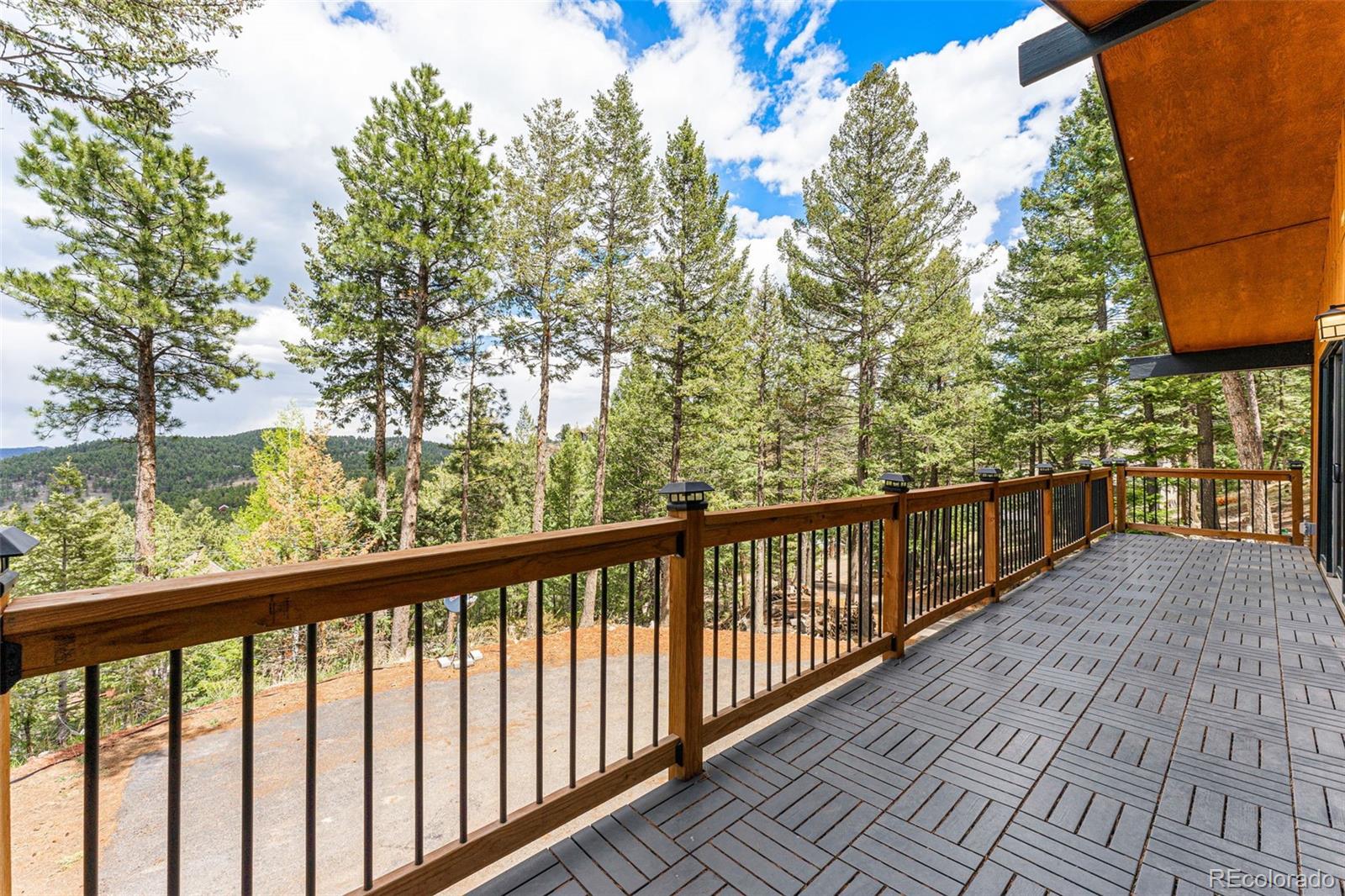 30242 Pine Crest Drive Evergreen, CO 80439 - Photo 10 of 28 a view of balcony with wooden floor and fence