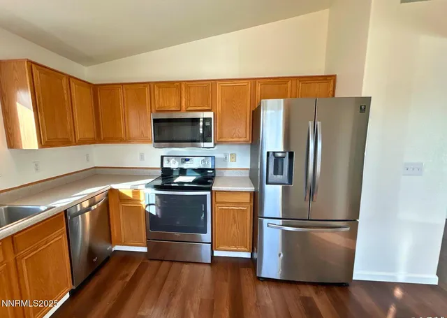 a kitchen with stainless steel appliances a refrigerator microwave and sink
