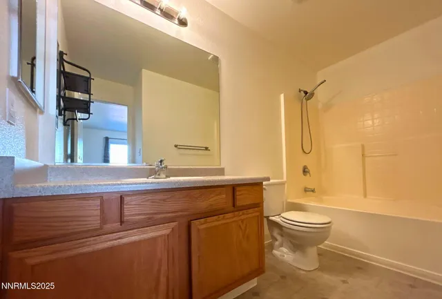 a bathroom with a granite countertop sink a toilet and a bathtub