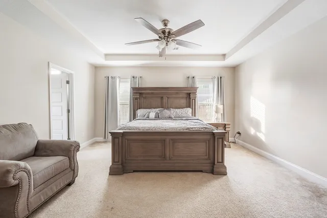 a spacious bedroom with a bed and a ceiling fan