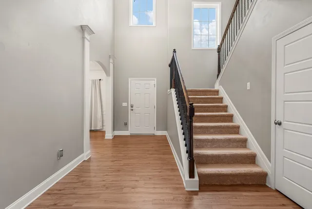 a dining room with wooden floor a chandelier a wooden table and chairs