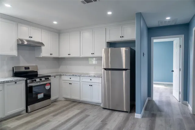 a kitchen with wooden floors and stainless steel appliances