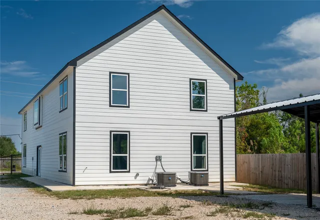 a view of a house with a yard and large tree