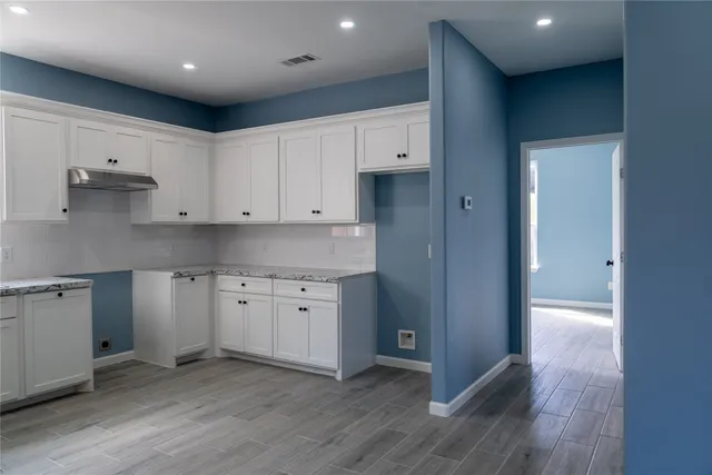 a kitchen with cabinets oven and a sink
