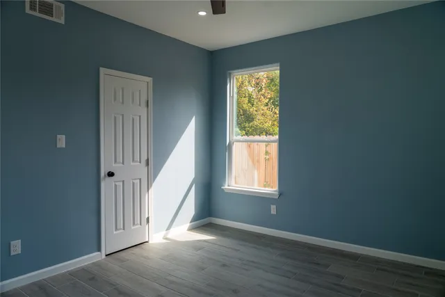 an empty room with wooden floor and a window