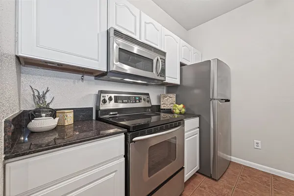 a kitchen with stainless steel appliances granite countertop a stove a microwave and cabinets
