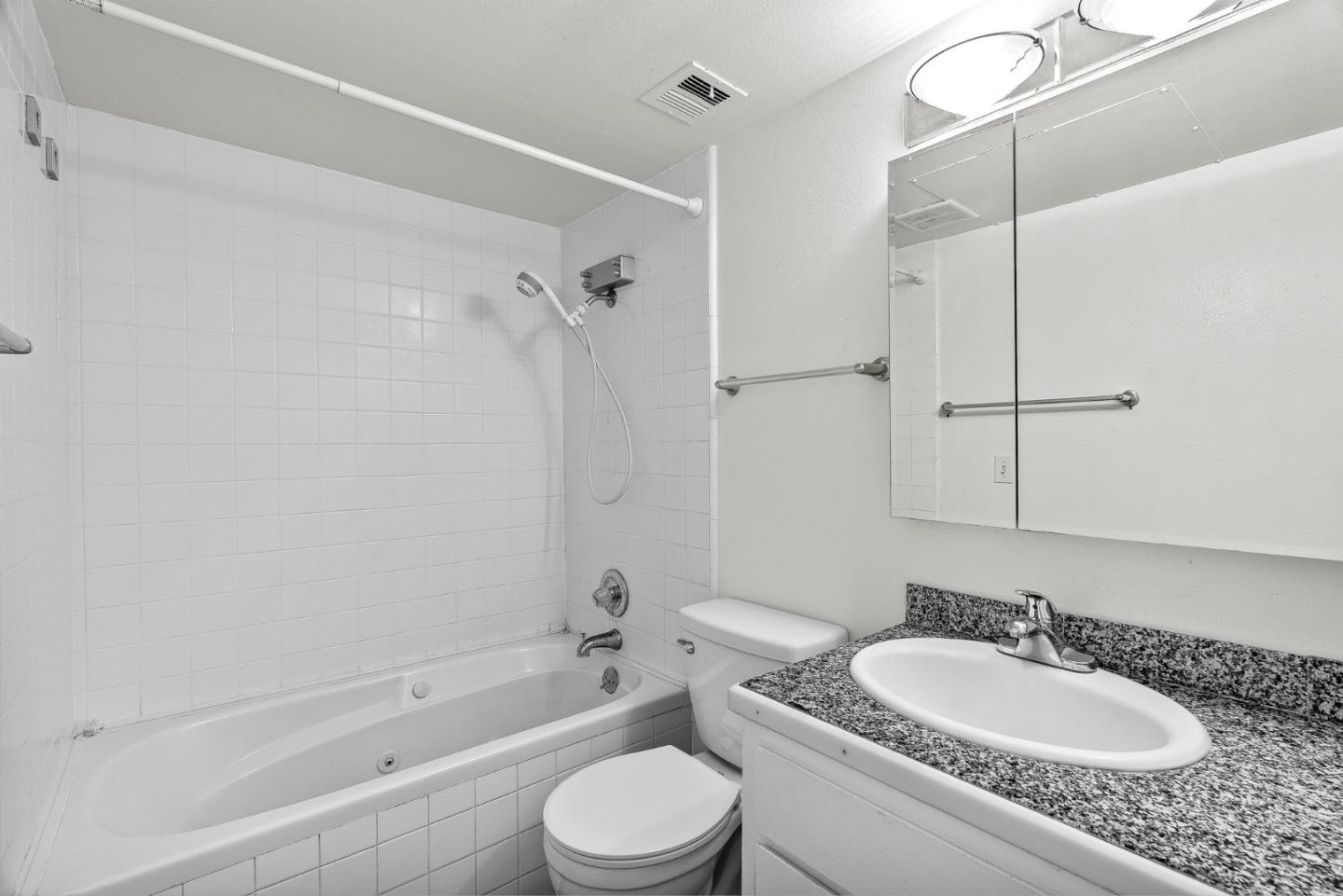 1925 46th Avenue, Unit 78 Capitola, CA 95010 - Photo 13 of 31 a bathroom with a granite countertop sink toilet a mirror and shower