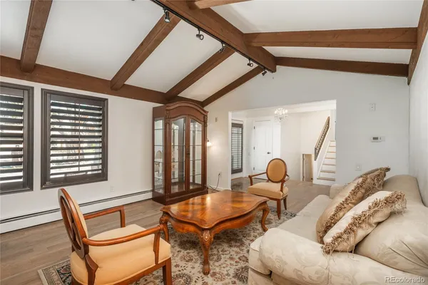 a kitchen with stainless steel appliances kitchen island granite countertop a stove a sink and white cabinets with wooden floor