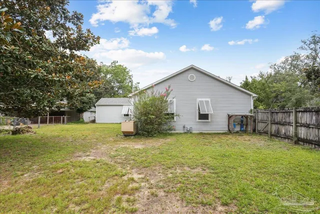 a backyard of a house with table and chairs