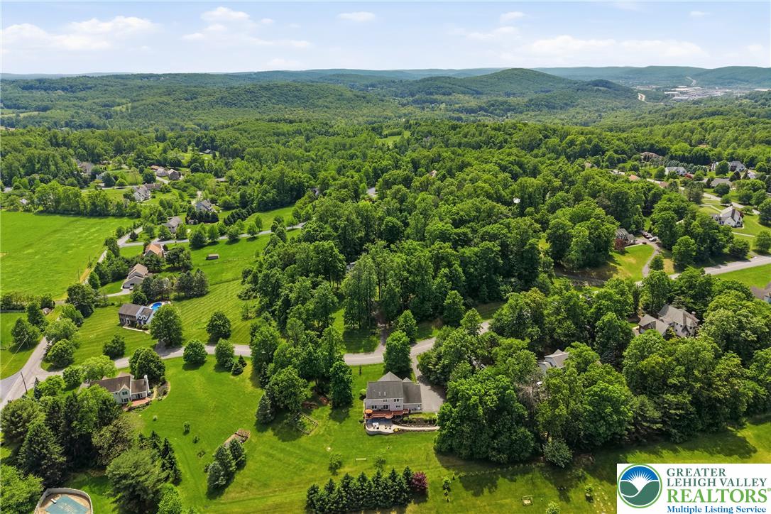 115 West Butternut Road Hellertown, PA 18055 - Photo 88 of 97 An aerial perspective reveals a harmonious blend of residential plots nestled within lush, tree-covered hills.