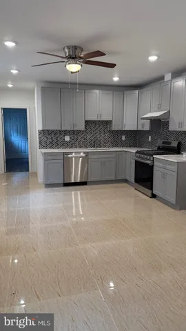 a large kitchen with a large counter top stainless steel appliances and cabinets