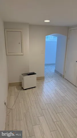 a view of an empty room with wooden floor and cabinet