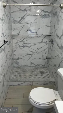a bathroom with a toilet and a shower