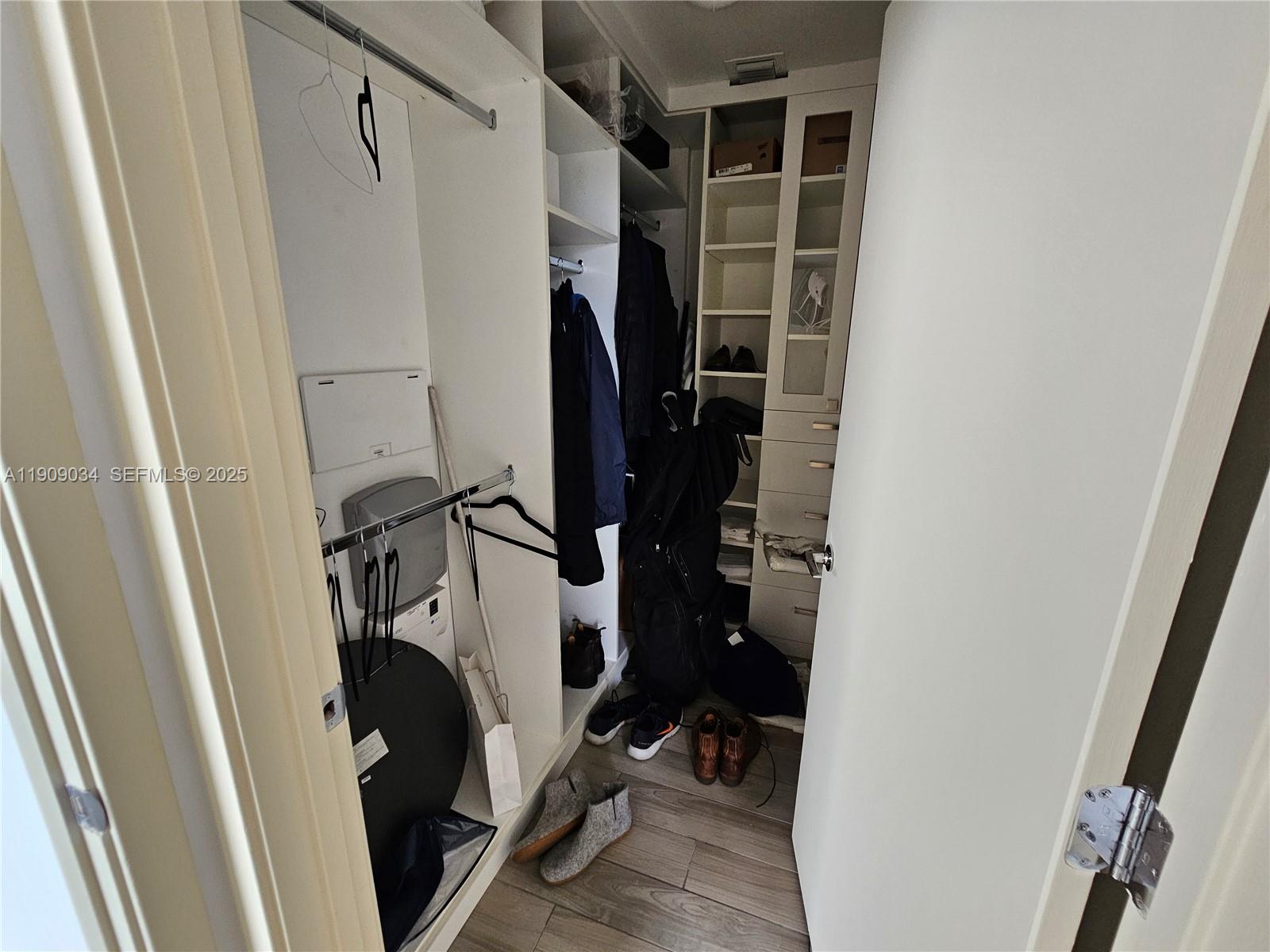 999 Southwest 1st Avenue, Unit 3004 Miami, FL 33130 - Photo 12 of 36 a view of walk in closet with clothes and shoes