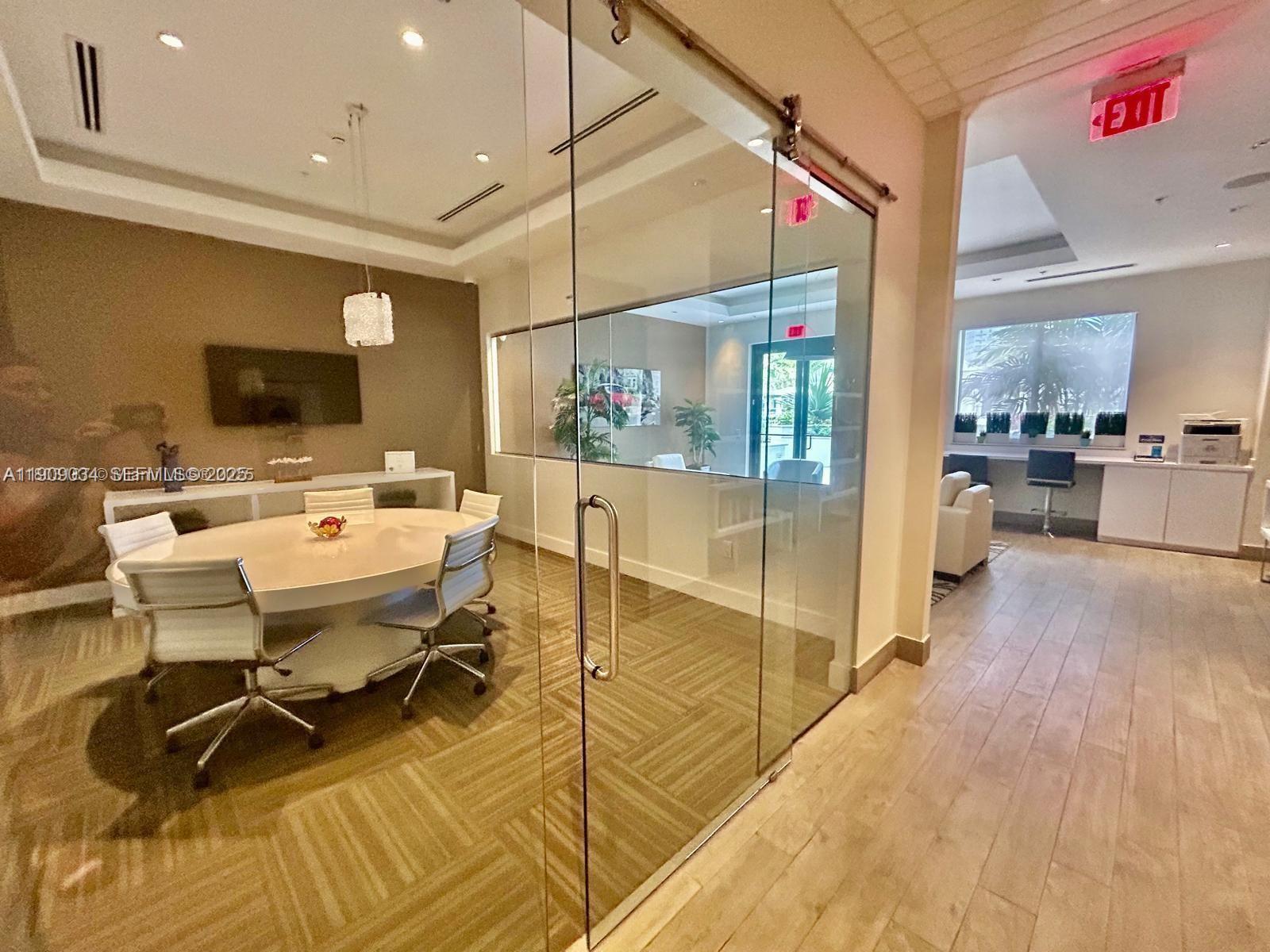 999 Southwest 1st Avenue, Unit 3004 Miami, FL 33130 - Photo 31 of 36 a workspace with wooden floor and a flat screen tv