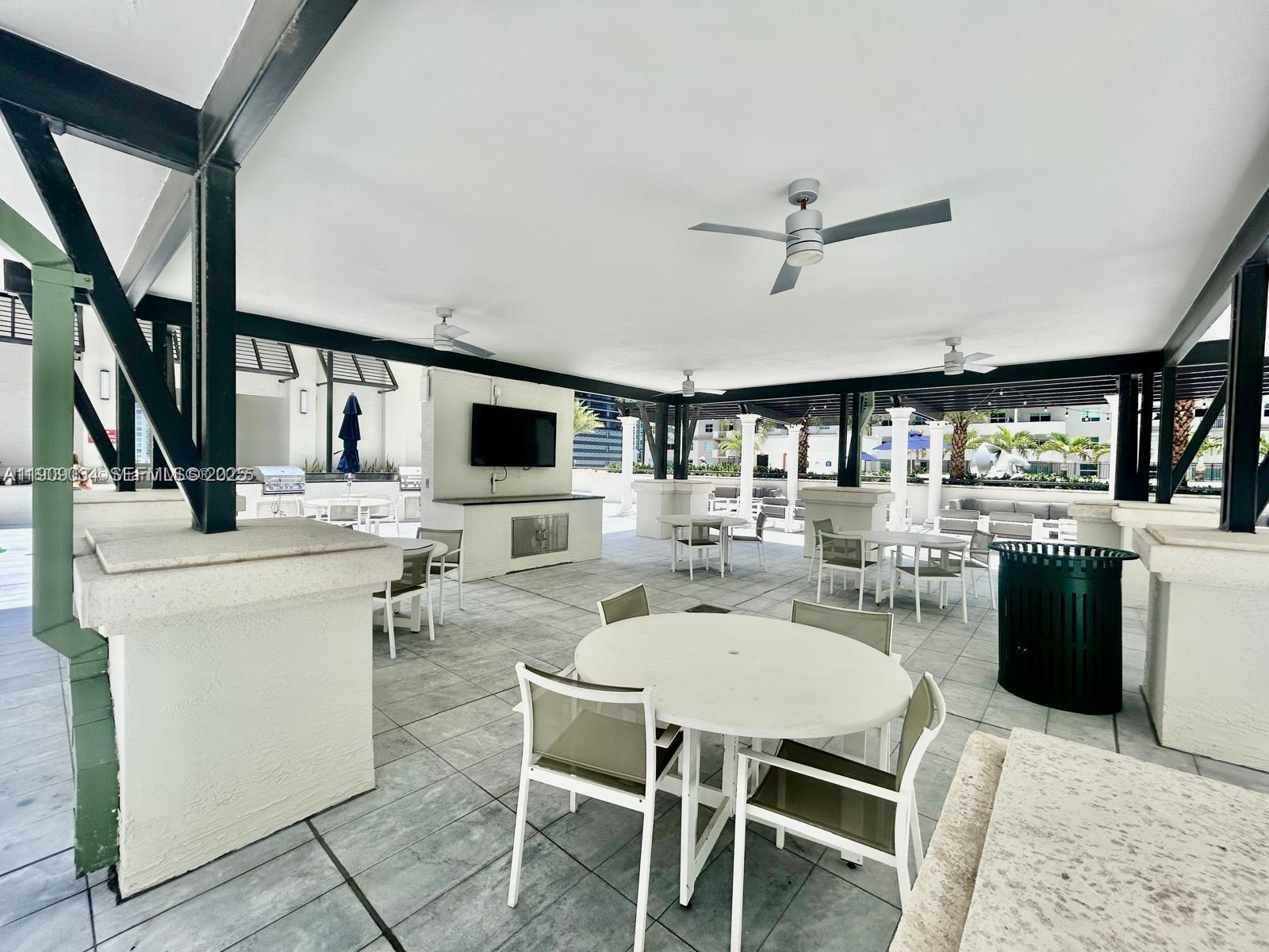 999 Southwest 1st Avenue, Unit 3004 Miami, FL 33130 - Photo 34 of 36 a dining room with wooden floor a chandelier fan a wooden table and chairs