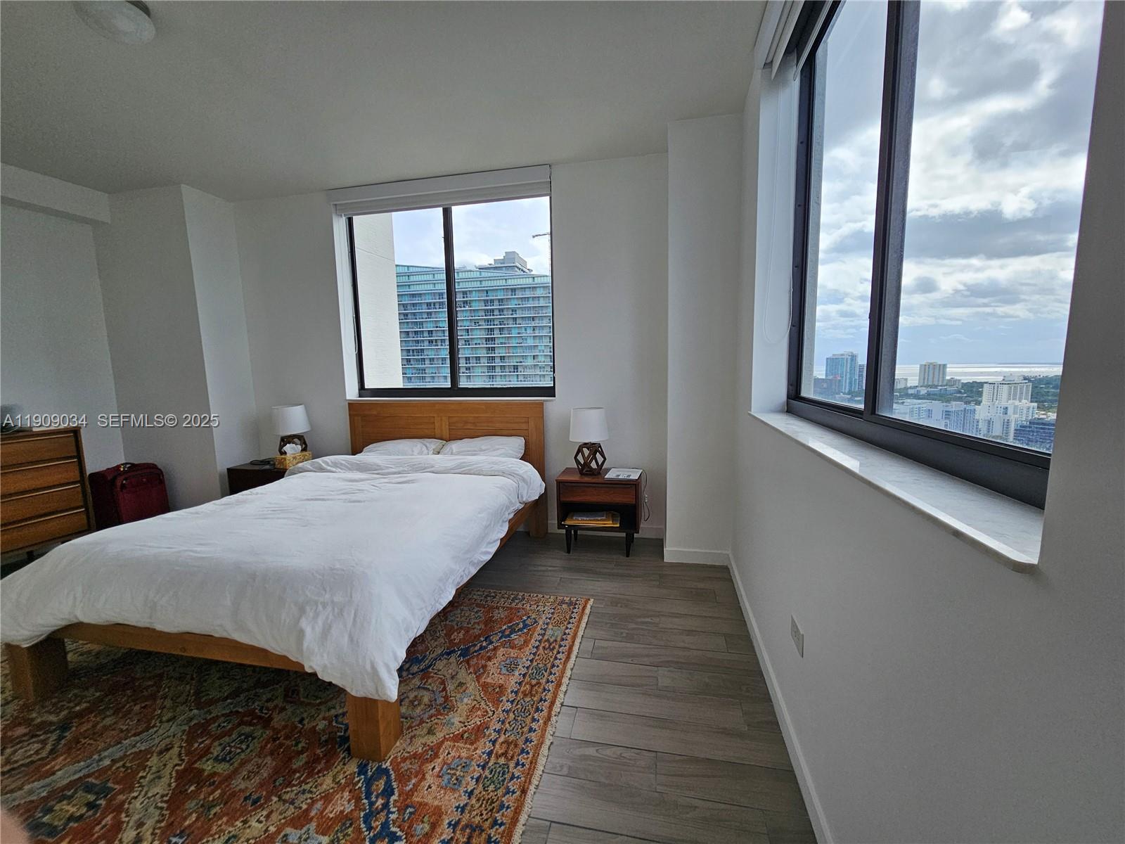 999 Southwest 1st Avenue, Unit 3004 Miami, FL 33130 - Photo 6 of 36 a bed sitting in a bedroom next to a window