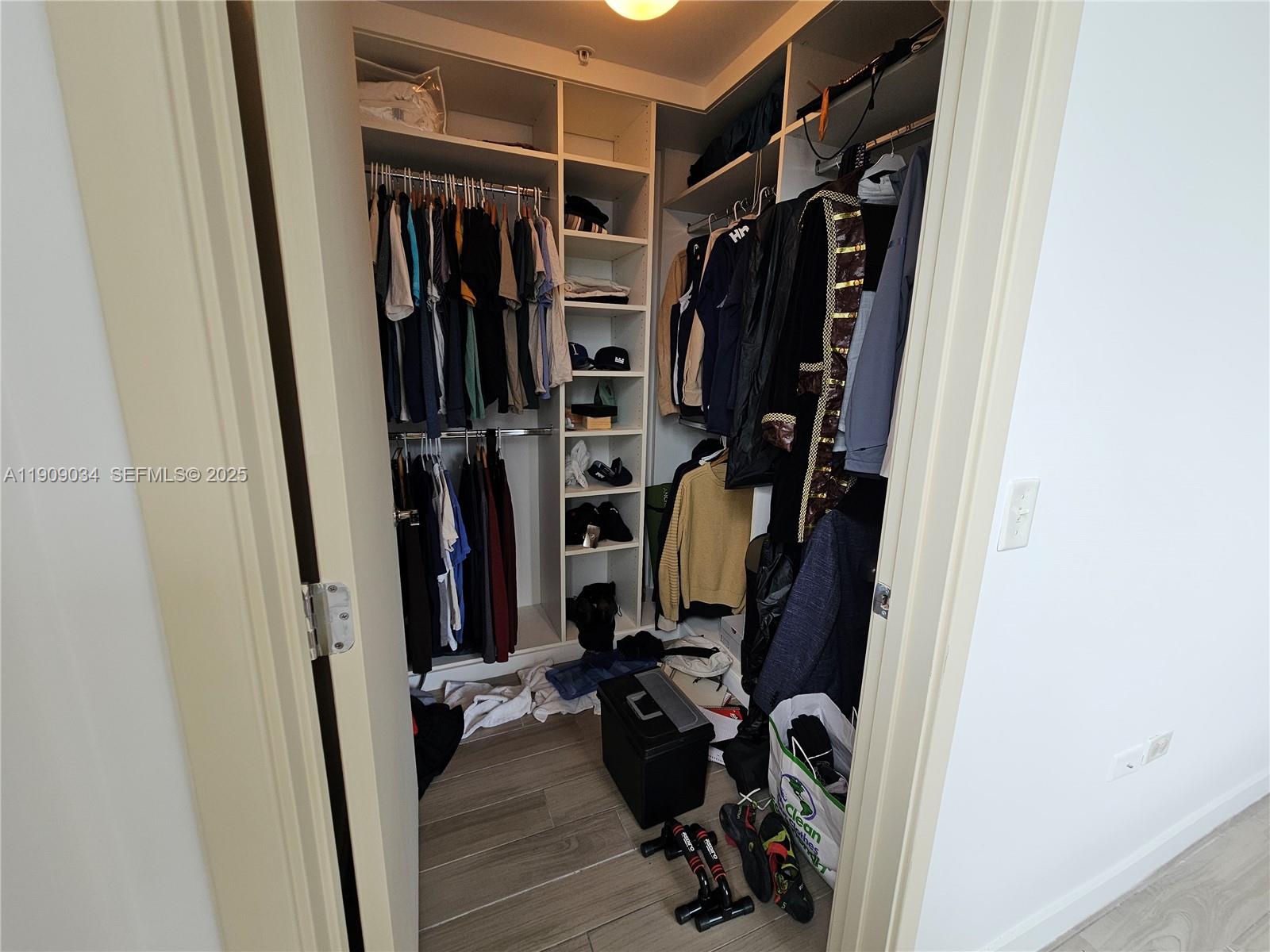 999 Southwest 1st Avenue, Unit 3004 Miami, FL 33130 - Photo 9 of 36 a view of walk in closet with clothes