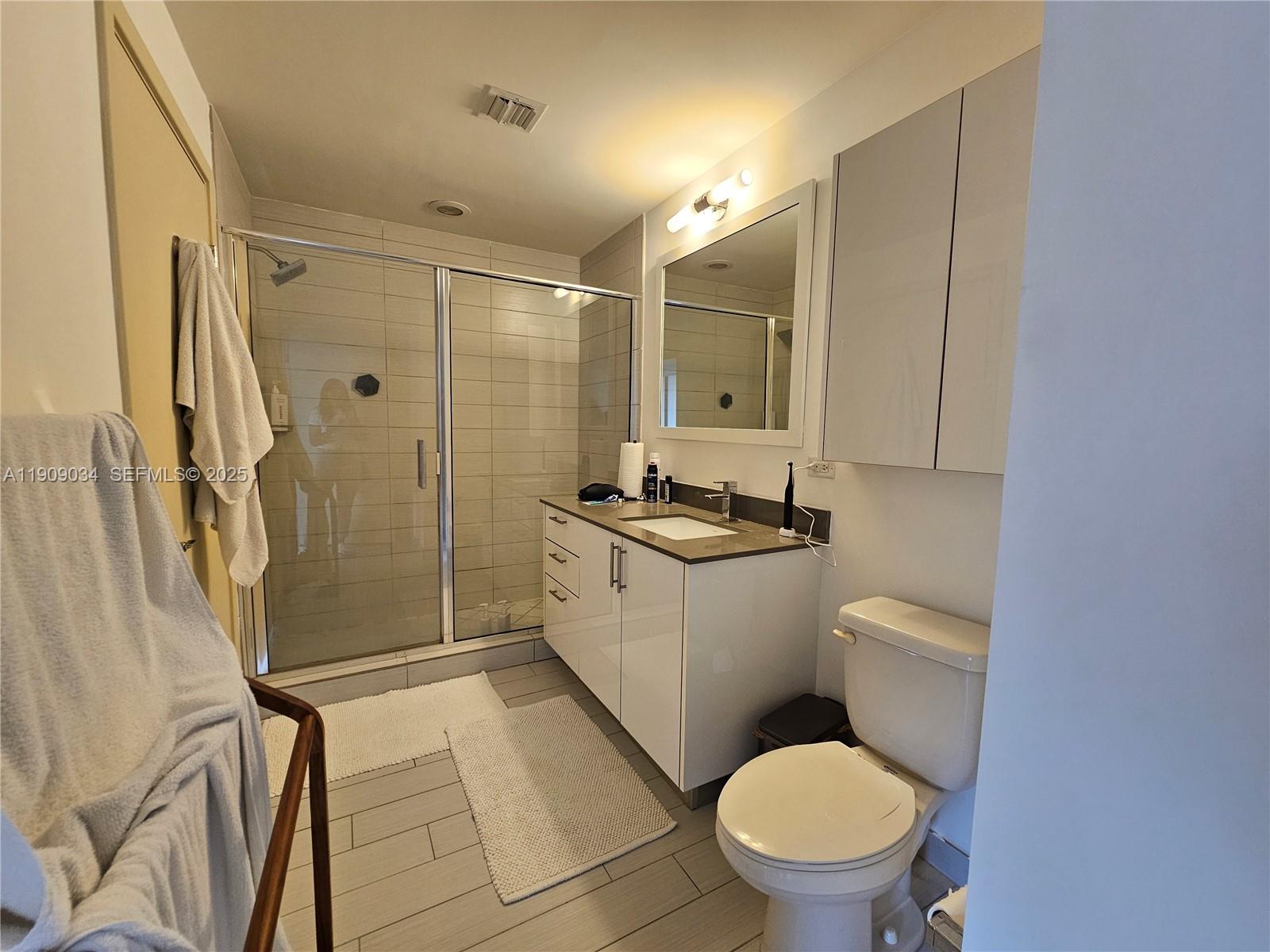 999 Southwest 1st Avenue, Unit 3004 Miami, FL 33130 - Photo 10 of 36 a bathroom with a granite countertop toilet sink and shower