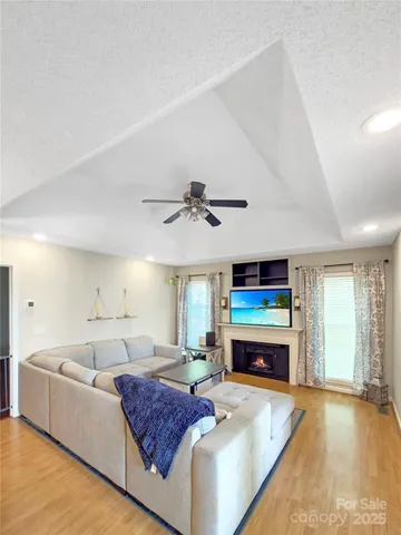 a living room with furniture a fireplace and a flat screen tv