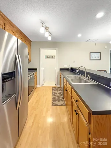 a kitchen with stainless steel appliances granite countertop a sink stove and refrigerator