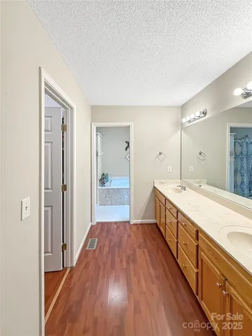 a spacious bathroom with a vanity a sink a mirror and a shower