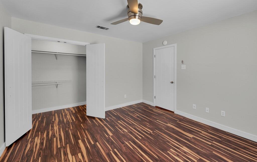 1362 South 12th Street, Unit 22 Waco, TX 76706 - Photo 19 of 31 Wood-finish flooring with a horizontal pattern, light gray walls, and a ceiling fan with integrated lighting