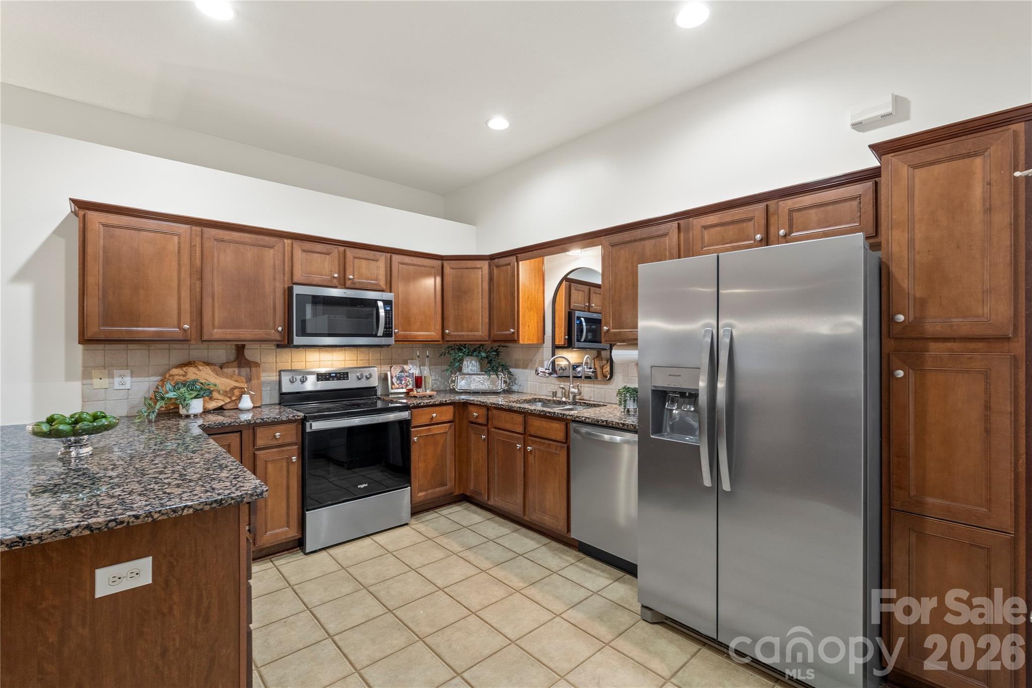 2444 Coltsview Lane Matthews, NC 28105 - Photo 11 of 43 a kitchen with stainless steel appliances granite countertop a refrigerator a stove top oven a sink and dishwasher