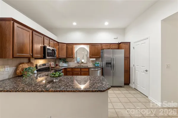 a kitchen with stainless steel appliances granite countertop a sink a stove a refrigerator a microwave and cabinets
