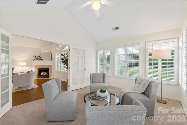 a living room with furniture large window and fireplace