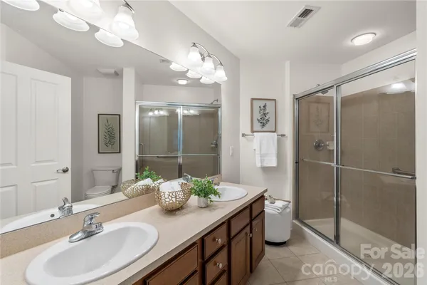 a bathroom with a double vanity sink mirror and shower