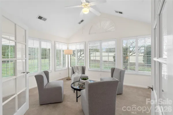 a living room with furniture and large windows