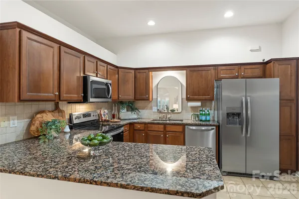 a kitchen with stainless steel appliances granite countertop a refrigerator sink and stove