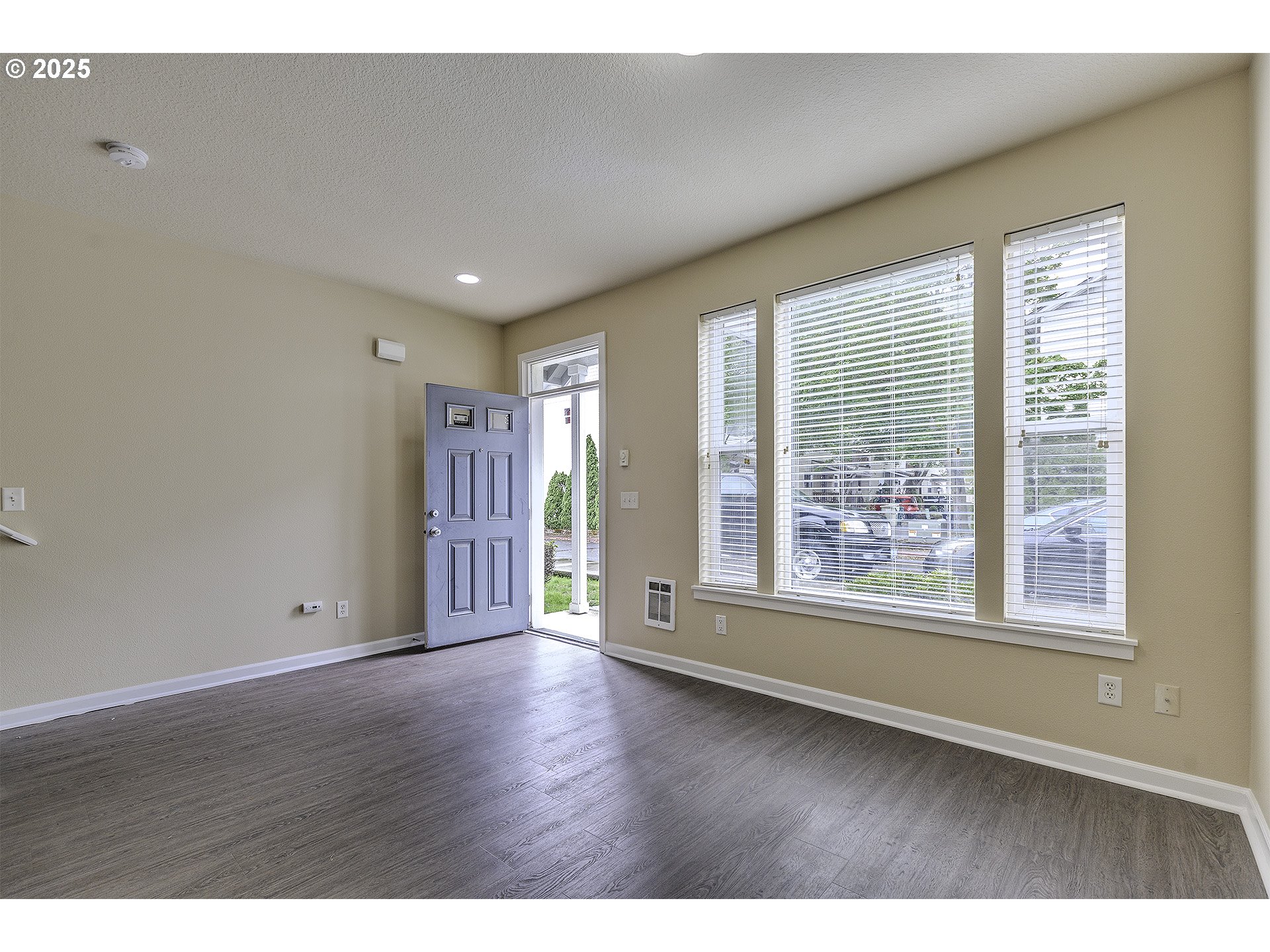 18483 Southwest Annamae Lane Beaverton, OR 97003 - Photo 3 of 23 a view of an empty room with wooden floor and a window