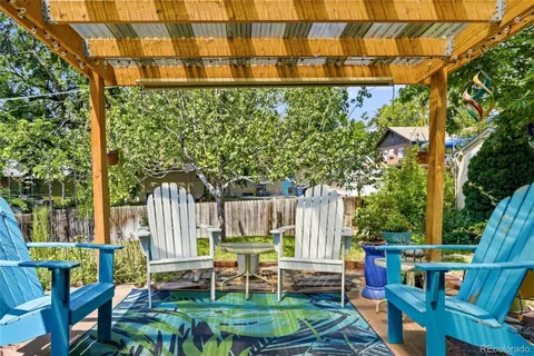 a view of a chair and table in backyard of the house
