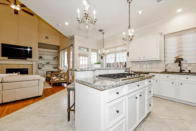 a kitchen with stainless steel appliances a stove a sink dishwasher a oven with a dining table and chairs