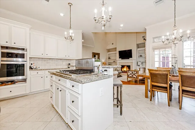 a kitchen with stainless steel appliances kitchen island granite countertop a refrigerator and a stove top oven