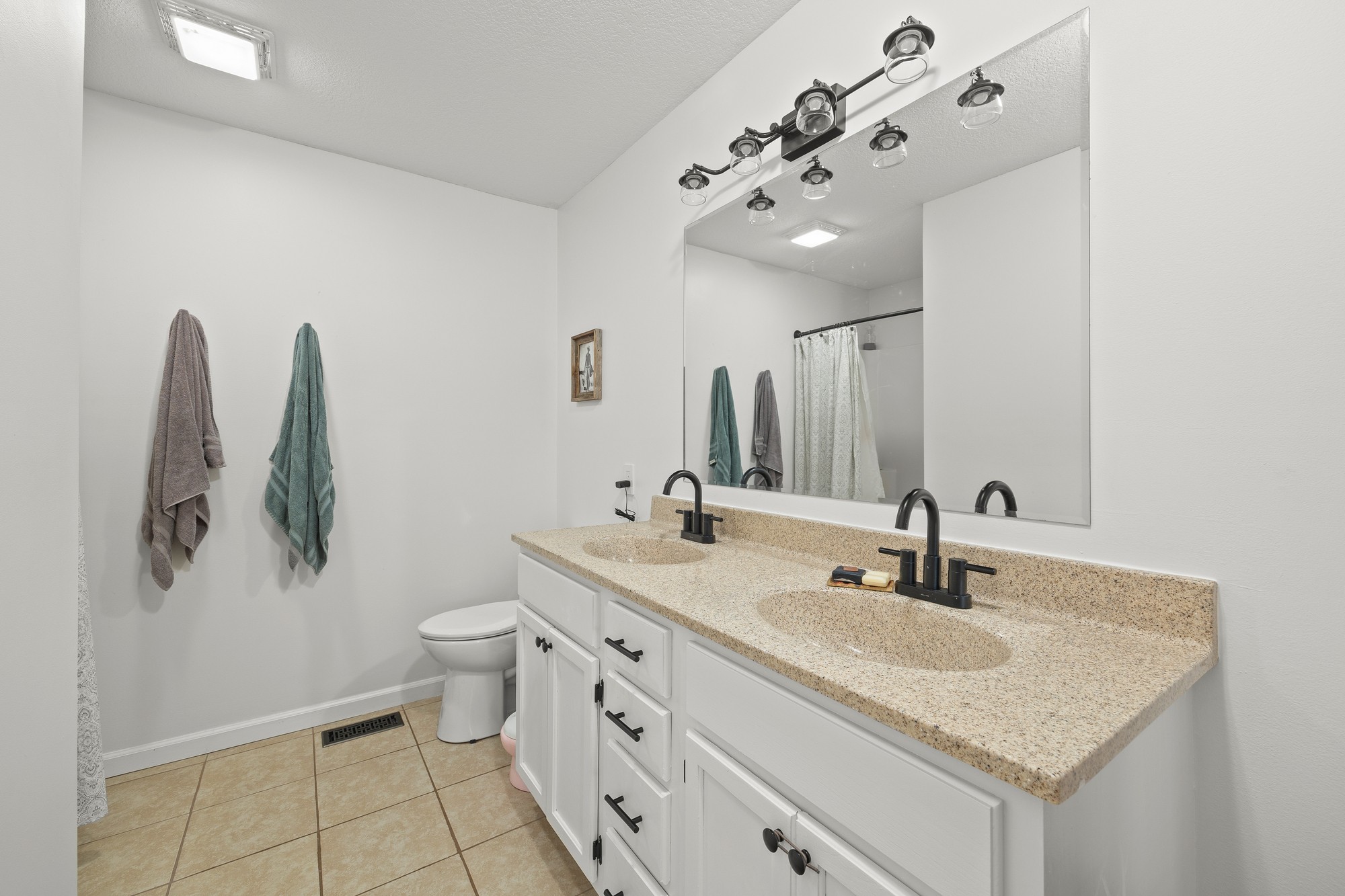 2195 Elmore Town Road Baxter, TN 38544 - Photo 12 of 26 a bathroom with a granite countertop sink a toilet and mirror