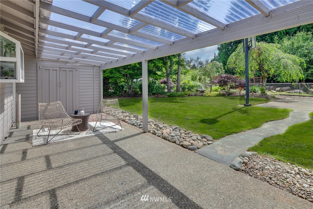 13833 Southeast 142nd Street Renton, WA 98059 - Photo 20 of 22 a view of a patio with table and chairs potted plants with wooden floor and fence